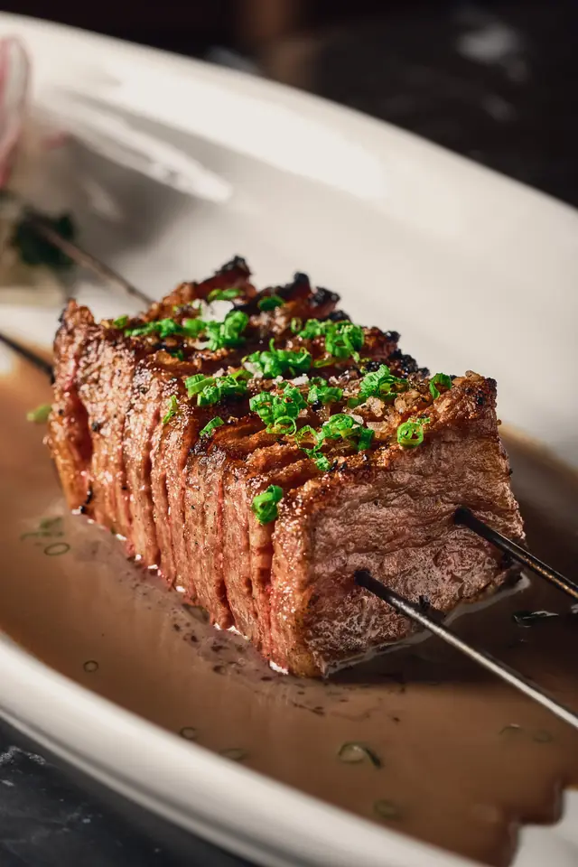 Sliced Japanese wagyu on a skewer, finished with chives